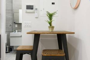 un tavolo con due sgabelli e una pianta in vaso di 78-4D Quality 1br W&D SKYLIGHT By Central Park a New York