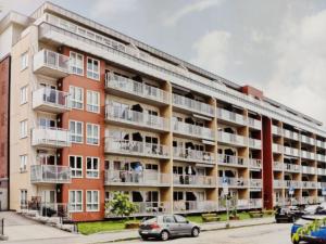 an apartment building with cars parked in front of it at Spacious and cozy study apartment with balcony in Oslo
