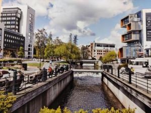 people walking over a bridge over a river in a city at Spacious and cozy study apartment with balcony in Oslo