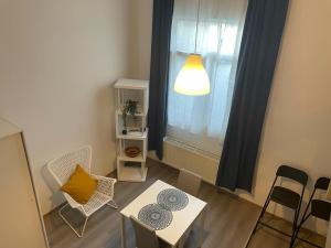 a living room with a table and chairs and a window at Sofieflat - Wallifolie in Charleroi