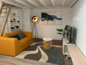a living room with a yellow couch and a television at Sofieflat - Wallifolie in Charleroi