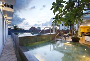 a swimming pool on the roof of a building at Amaris Hotel Teuku Umar in Denpasar