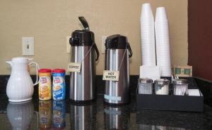 uma bancada com comodidades para preparar café e algumas chávenas em GreenTree Inn - IAH Airpot JFK Blvd em Houston