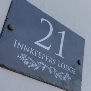 The Innkeeper’s Lodge Bushmills في بوشميلس: لافته مكتوب عليها نزل interget عليه ورد
