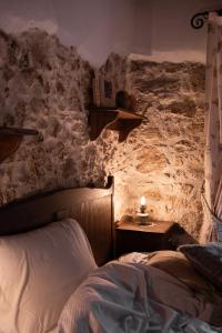 een slaapkamer met een bed en een stenen muur bij Aremogna - Dimora Rosy in Roccaraso