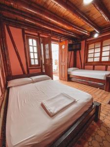 a bedroom with two beds in a room with windows at Hostal Victoria Club A&C in Arboletes