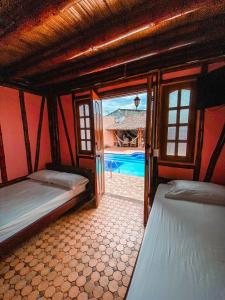 a room with two beds and a swimming pool at Hostal Victoria Club A&C in Arboletes