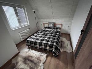 Chyše的住宿－Chata s panoramatickou saunou，一间卧室配有一张床,床上铺有铺着条纹毯子