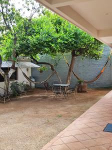 un patio con mesa, sillas y un árbol en Casa Sixta, en Puerto Escondido