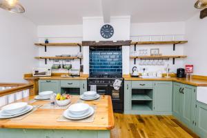 a kitchen with blue cabinets and a wooden table at Ivy House Luxury Cheshire Cottage for relaxation. Chester Zoo· in Saughall