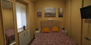 a bedroom with a bed with two orange pillows on it at New Apartment & Parking Alcazaba in Málaga