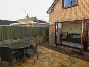 a patio with a table and chairs and a couch at Penn Lea in Tenby