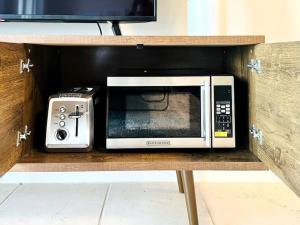 a microwave and a toaster oven on a shelf at Beachfront Stylish Condo - Stunning Views! in Gulf Shores