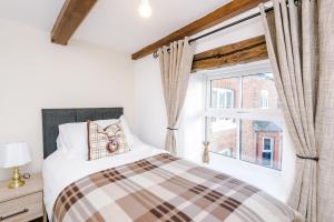 Ivy House Luxury Cheshire Cottage for relaxation. Chester Zoo· في Saughall: غرفة نوم بسرير ونافذة