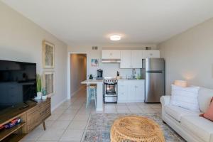 a living room with a couch and a kitchen at Beachfront Stylish Condo - Stunning Views! in Gulf Shores