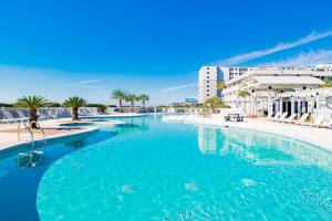 a large pool with blue water in a resort at Beachfront Stylish Condo - Stunning Views! in Gulf Shores