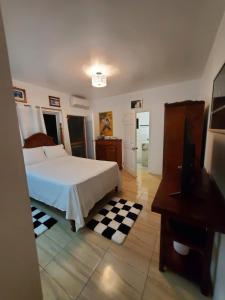 Centrally Located Room - 5 في بورت أنطونيو: غرفة نوم مع سرير أبيض وأرضية لوح شوكولاتة.