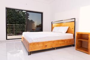 a bedroom with a bed and a large window at Yoyo Kunda in Banjul