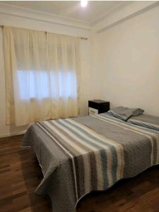 ein Schlafzimmer mit einem Bett mit einer gestreiften Decke in der Unterkunft Departamento Shoping Alto Noa in Salta