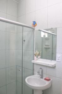 乌巴图巴Ubatuba Wild Surf Hostel的带水槽和玻璃淋浴间的浴室