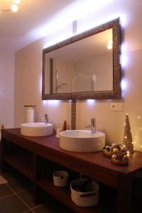 uma casa de banho com 2 lavatórios e um espelho grande em B&B Maison Durbois em Durbuy