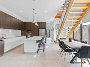 an open kitchen and dining room with a table and chairs at North Entrance Holiday Home in The Entrance
