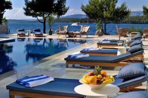 einen Pool mit Tischen und Stühlen und eine Obstschale in der Unterkunft Waterfront Villa Antica, Cheerful 8 bedrooms with pool-Luxury is personal in Stari Grad