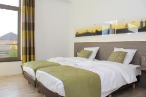 um quarto com 2 camas e uma grande janela em Mondo hôtel em Tubize