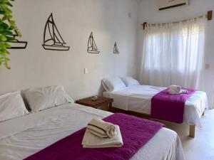 Camino al Mar في Ipala: سريرين في غرفة مع أشرعة على الحائط