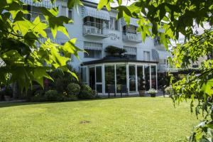 a building with a lawn in front of it at Hotel Riviera Blu in Tirrenia