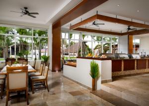un restaurante con mesas, sillas y ventanas en Sunscape Dorado Pacifico Ixtapa Resort & Spa- All Inclusive en Ixtapa