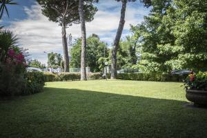 a park with palm trees and a grass yard at Hotel Riviera Blu in Tirrenia