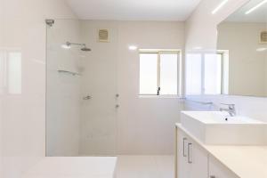 Un baño blanco con ducha y lavabo. en Sandy Beach House Corlette Unit 1 Waterfront WI-FI Aircon, en Corlette 32 fotos más