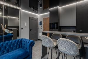 salon z niebieską kanapą i krzesłami w obiekcie Apartament NEGRO Gliwice - nowe osiedle, klimatyzacja, parking w mieście Gliwice
