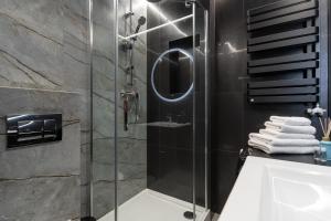 łazienka z przeszkloną kabiną prysznicową i umywalką w obiekcie Apartament NEGRO Gliwice - nowe osiedle, klimatyzacja, parking w mieście Gliwice
