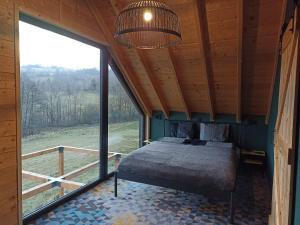 a bedroom with a bed and a large window at Maraśka Holiday House in Kamienna Góra