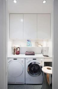 a white kitchen with a washing machine in a room at Fully furnished room for rent in Märsta in Märsta