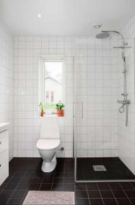 a bathroom with a toilet and a glass shower at Fully furnished room for rent in Märsta in Märsta