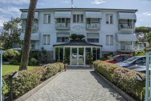 a white building with cars parked in front of it at Hotel Riviera Blu in Tirrenia