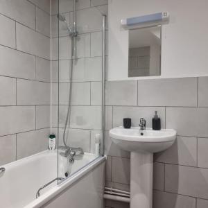 a white bathroom with a sink and a shower at Classic 2 bed apartment in oldkent road in London