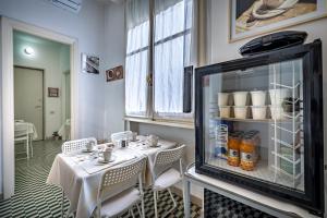 a dining room with a table and chairs and a refrigerator at Maison Bianca B&B in Florence
