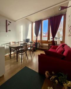 - un salon avec un canapé rouge et une table dans l'établissement Miti's House, à Sestrières