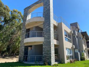 ein Apartmenthaus mit einer Steinsäule in der Unterkunft Complejo Bosque y Mar in San Clemente del Tuyú