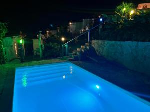ein Pool in der Nacht mit blauen Lichtern in der Unterkunft Studio Ti’ Colibri in Sainte-Marie