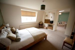 a bedroom with a large bed and a living room at The Marquess of Exeter in Uppingham