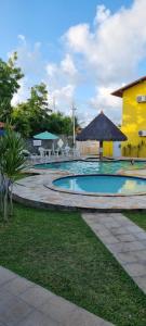 una piscina frente a un edificio amarillo en Casa12_Carneiros, en Tamandaré