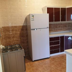 a kitchen with a white refrigerator and a stove at شاليهات لافندر الباحه بلجرشي in Baljurashi