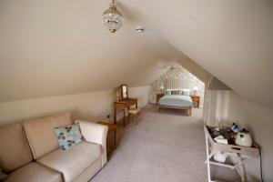 a living room with a couch and a bedroom at The Marquess of Exeter in Uppingham