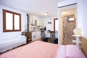 a bedroom with a bed and a kitchen with a table at Locazioni Turistiche By Max in Montegrotto Terme