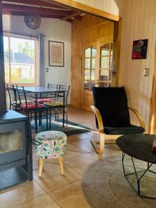 Casa El Arrebol, sector Saltos del Laja في Cabrero: غرفة معيشة مع طاولة وكراسي وموقد